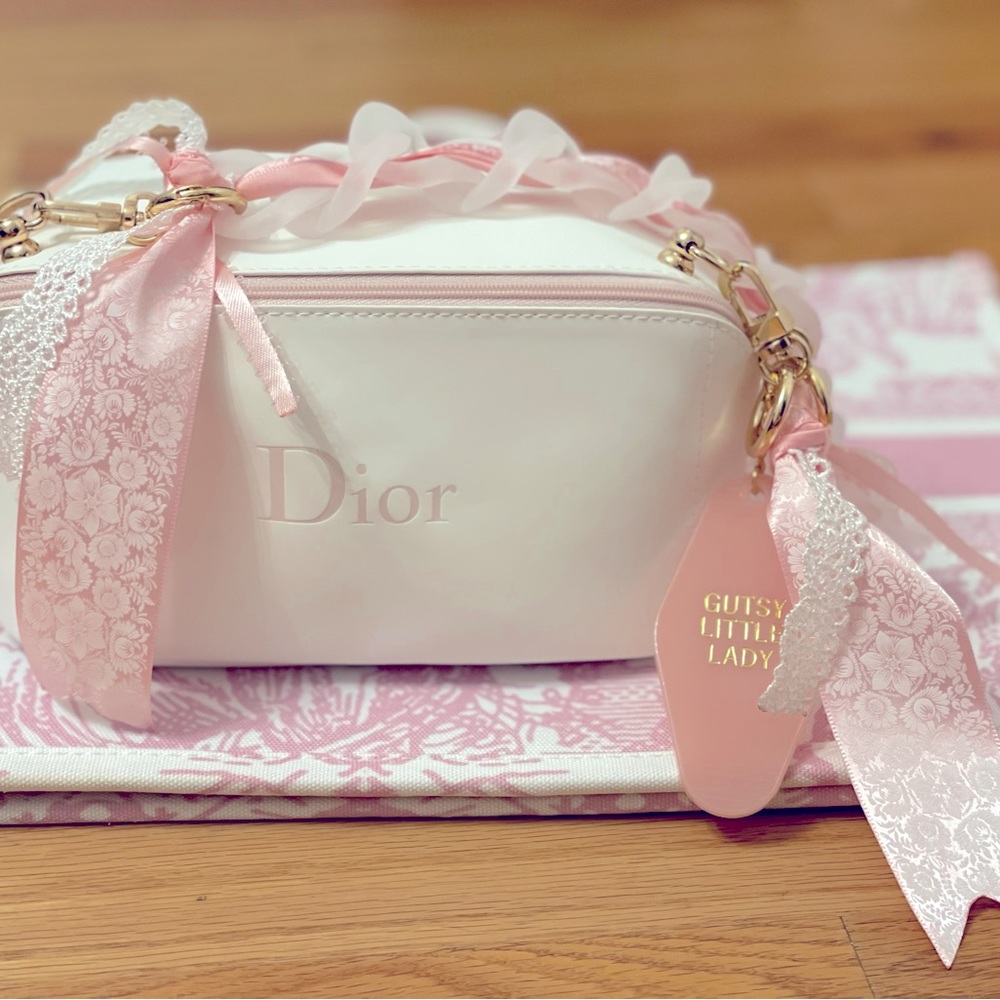 Dior purse in white and pink polyurethane with pink Dior logo on front.
